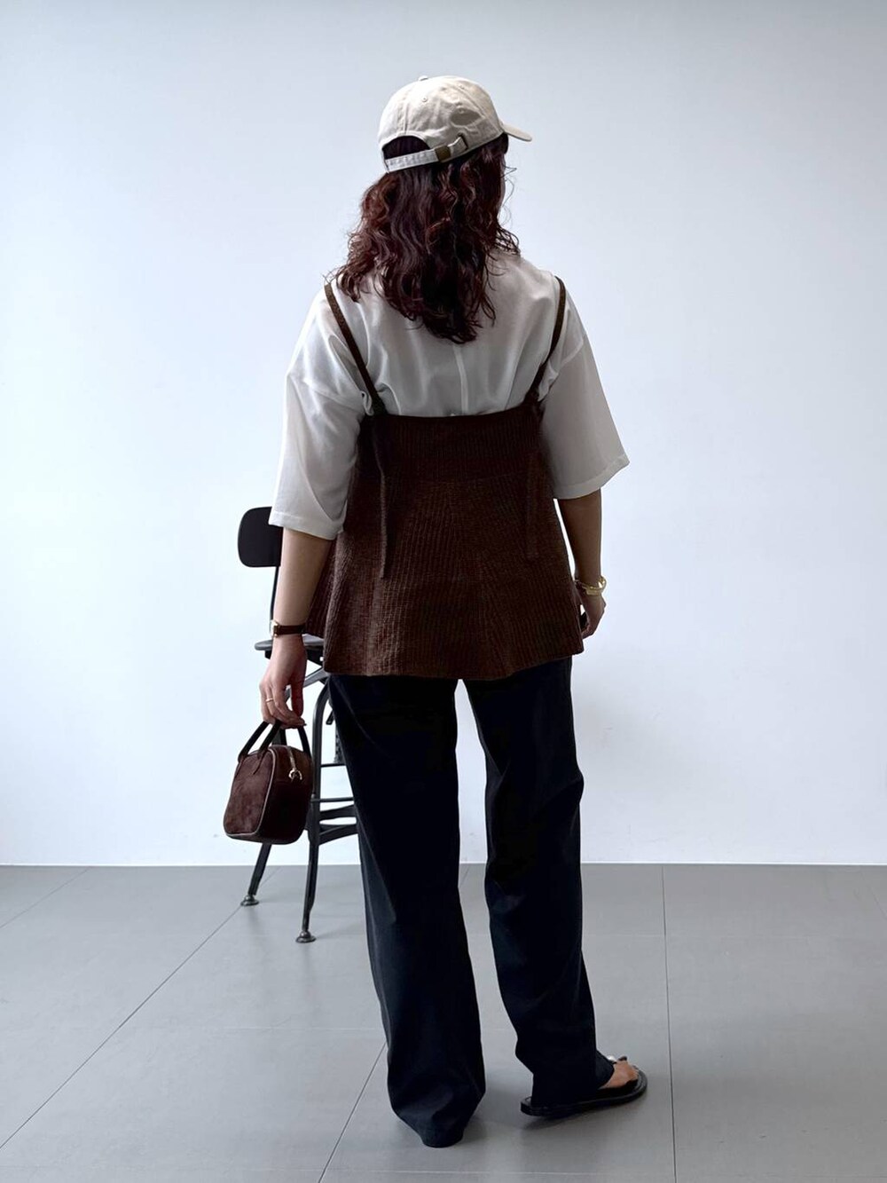 ホワイト系のシャツ/ブラウス、ブラック系のチノパンツ、ブラウン系のキャミソールを着用したレディースの秋コーディネートの5枚目の写真