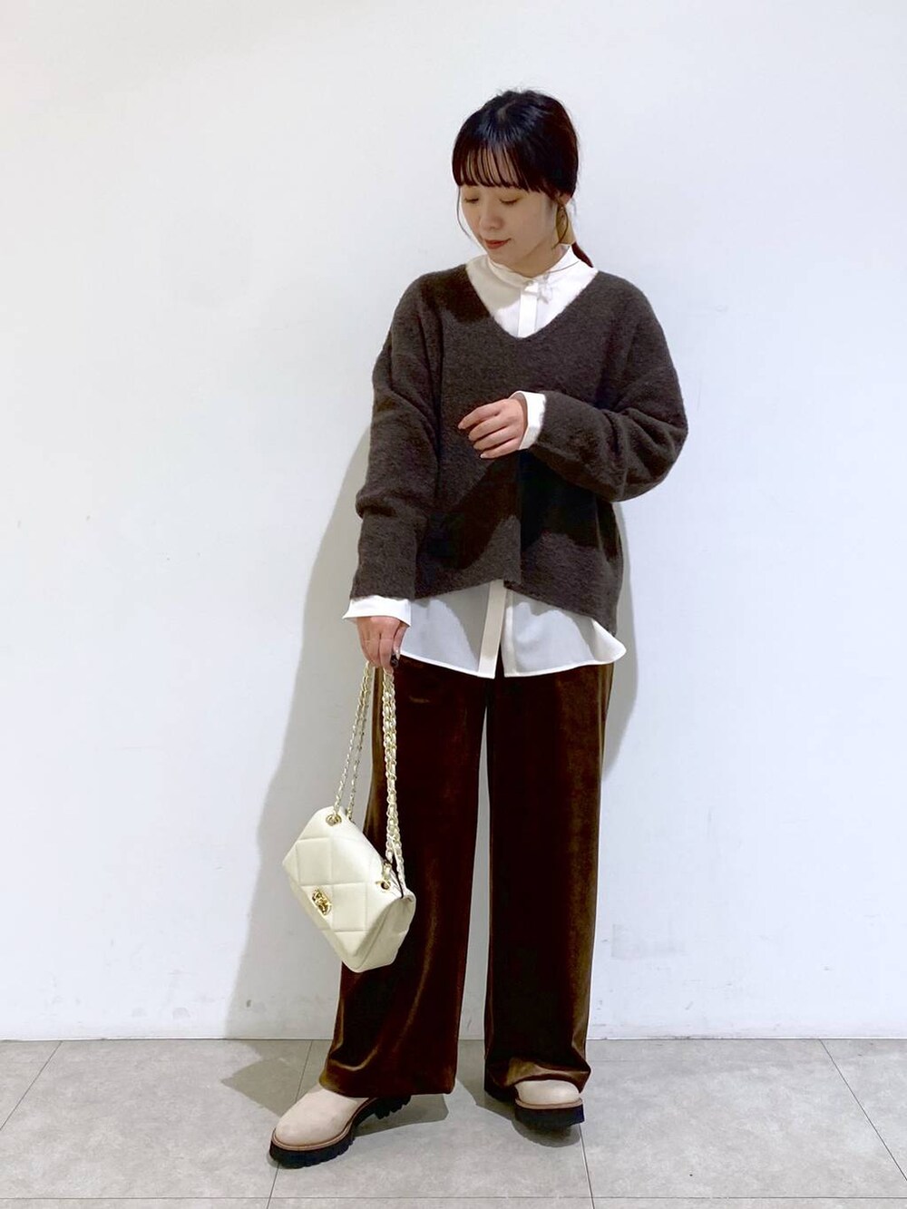 ベージュ系のブーツ、ホワイト系のショルダーバッグ、ホワイト系のシャツ/ブラウスを着用したレディースの冬コーディネートの6枚目の写真