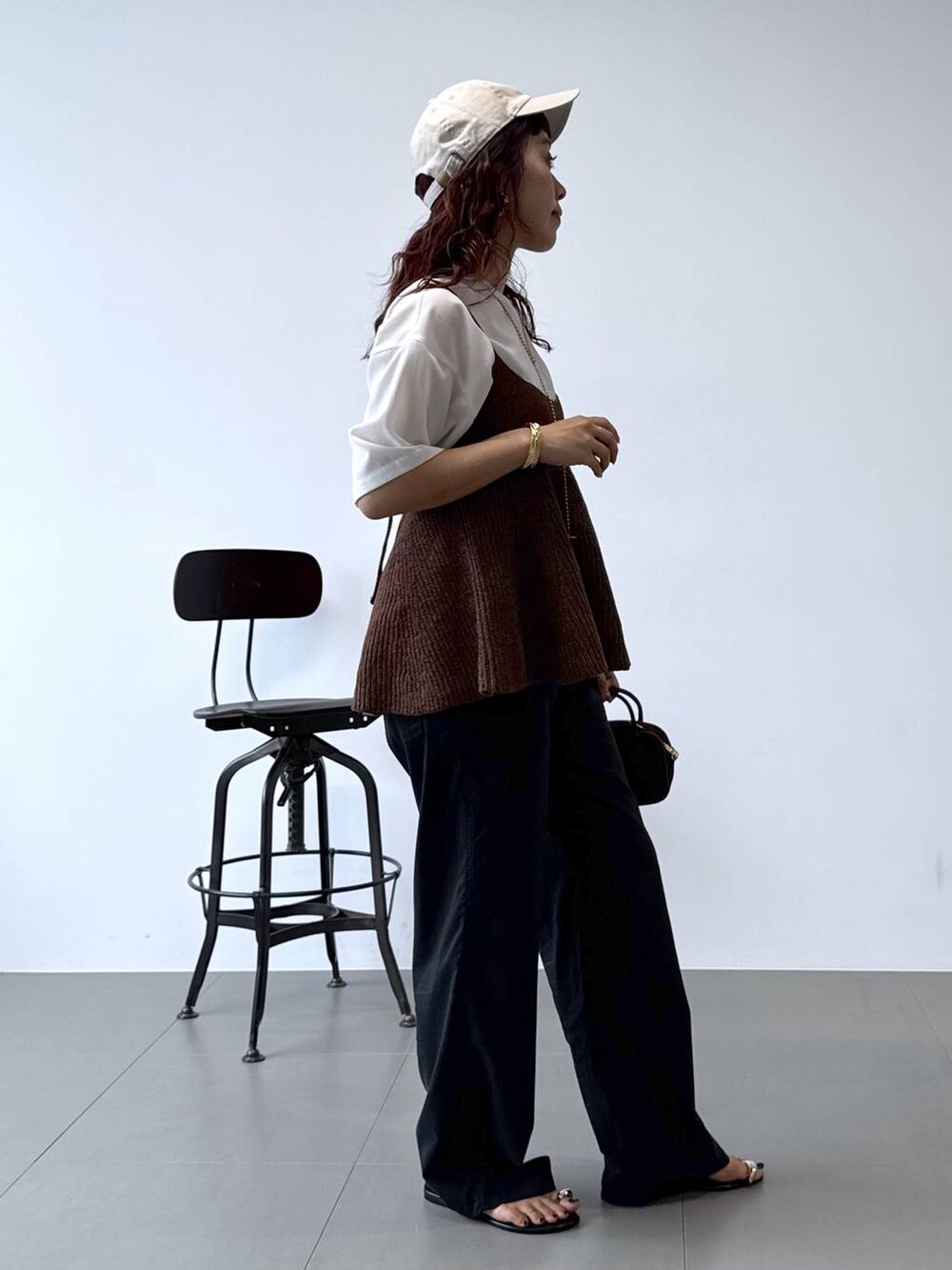 ホワイト系のシャツ/ブラウス、ブラック系のチノパンツ、ブラウン系のキャミソールを着用したレディースの秋コーディネートの4枚目の写真