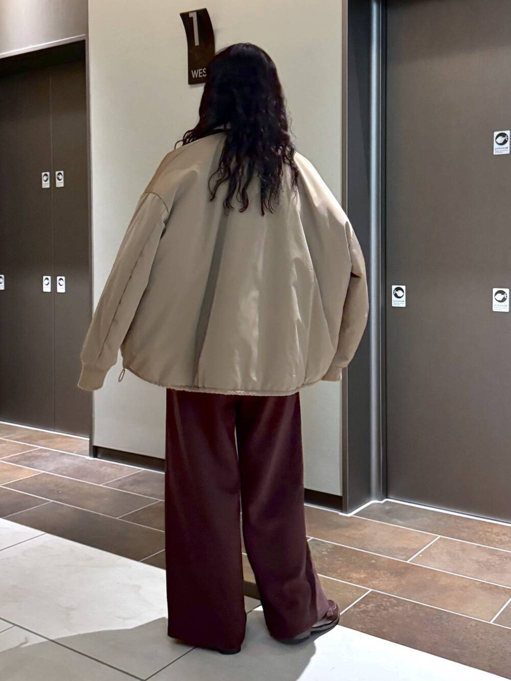 ベージュ系のブルゾン、ベージュ系のショルダーバッグ、ホワイト系のスウェットを着用したレディースの冬コーディネートの4枚目の写真