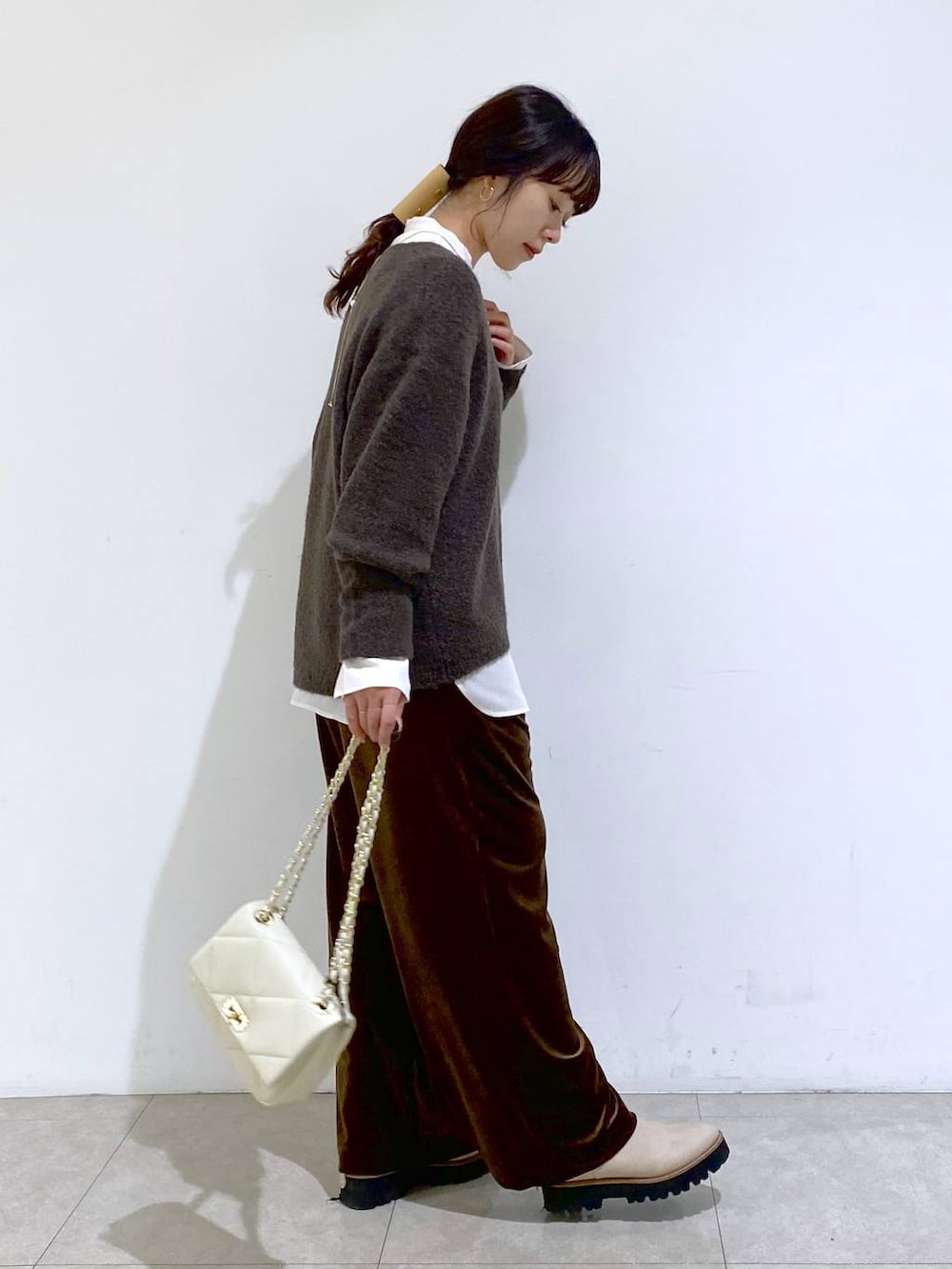 ベージュ系のブーツ、ホワイト系のショルダーバッグ、ホワイト系のシャツ/ブラウスを着用したレディースの冬コーディネートの5枚目の写真