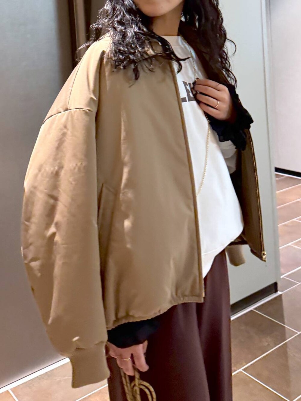 ベージュ系のブルゾン、ベージュ系のショルダーバッグ、ホワイト系のスウェットを着用したレディースの冬コーディネートの8枚目の写真