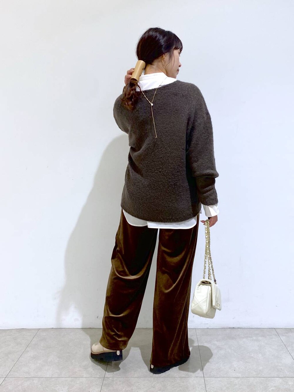 ベージュ系のブーツ、ホワイト系のショルダーバッグ、ホワイト系のシャツ/ブラウスを着用したレディースの冬コーディネートの4枚目の写真