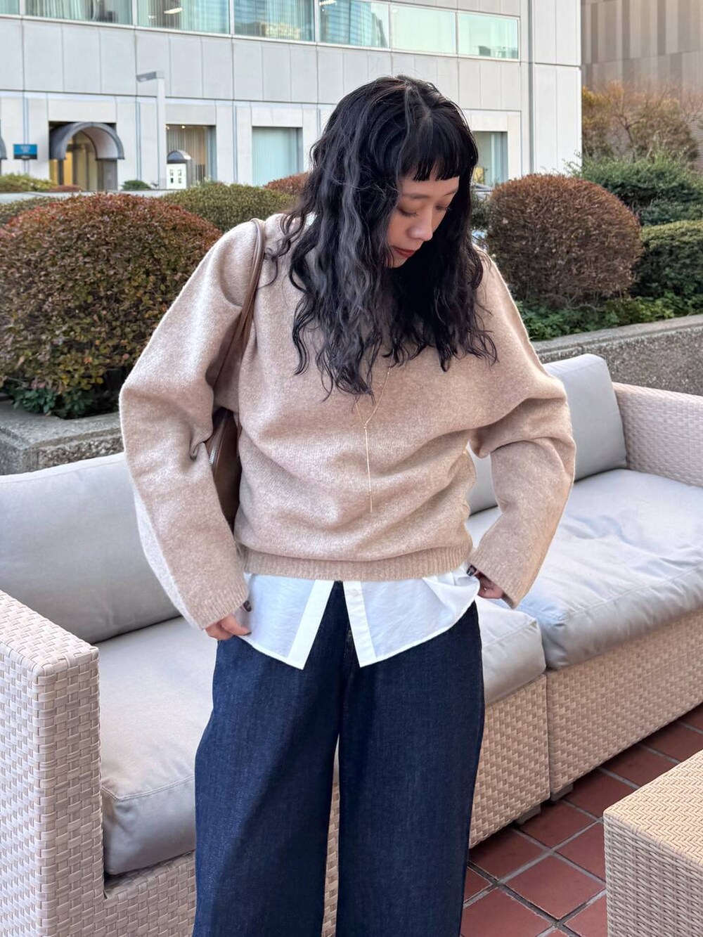 ブルー系のデニムパンツ、イエロー系のトートバッグ、ベージュ系のブーツを着用したレディースの冬コーディネートの5枚目の写真