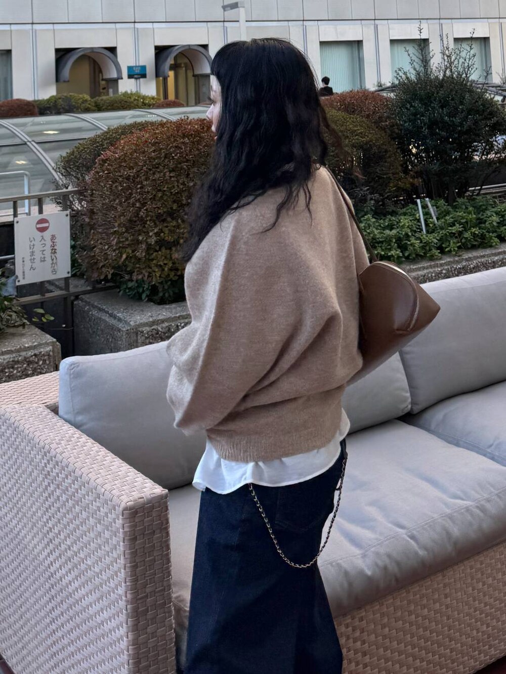 ブルー系のデニムパンツ、イエロー系のトートバッグ、ベージュ系のブーツを着用したレディースの冬コーディネートの6枚目の写真