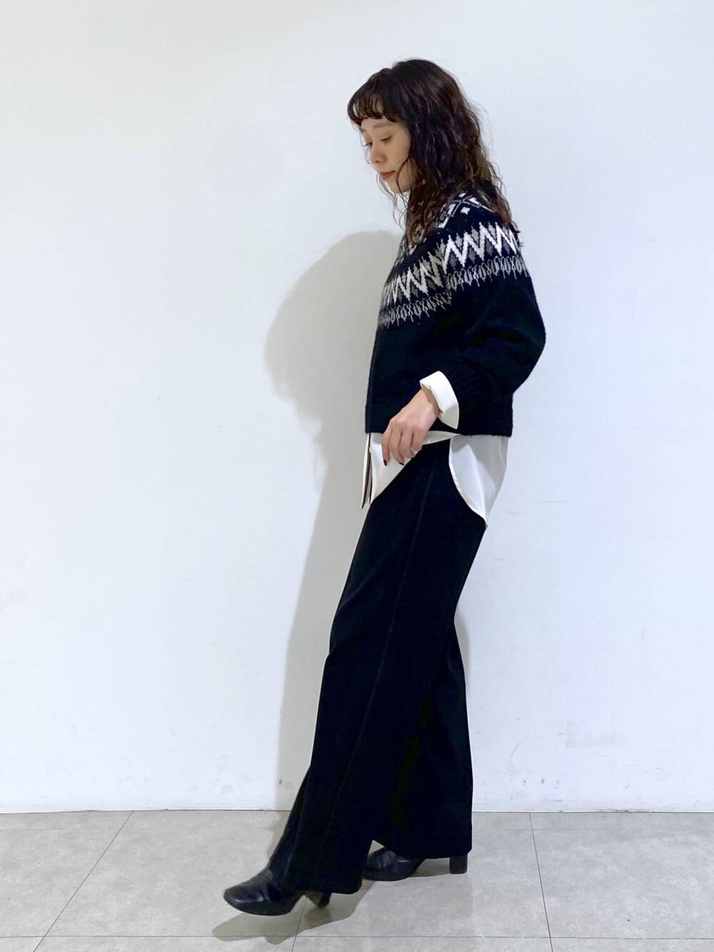 シルバー系のショルダーバッグ、ブラック系のTシャツ/カットソー、ホワイト系のシャツ/ブラウスを着用したレディースの冬コーディネートの2枚目の写真