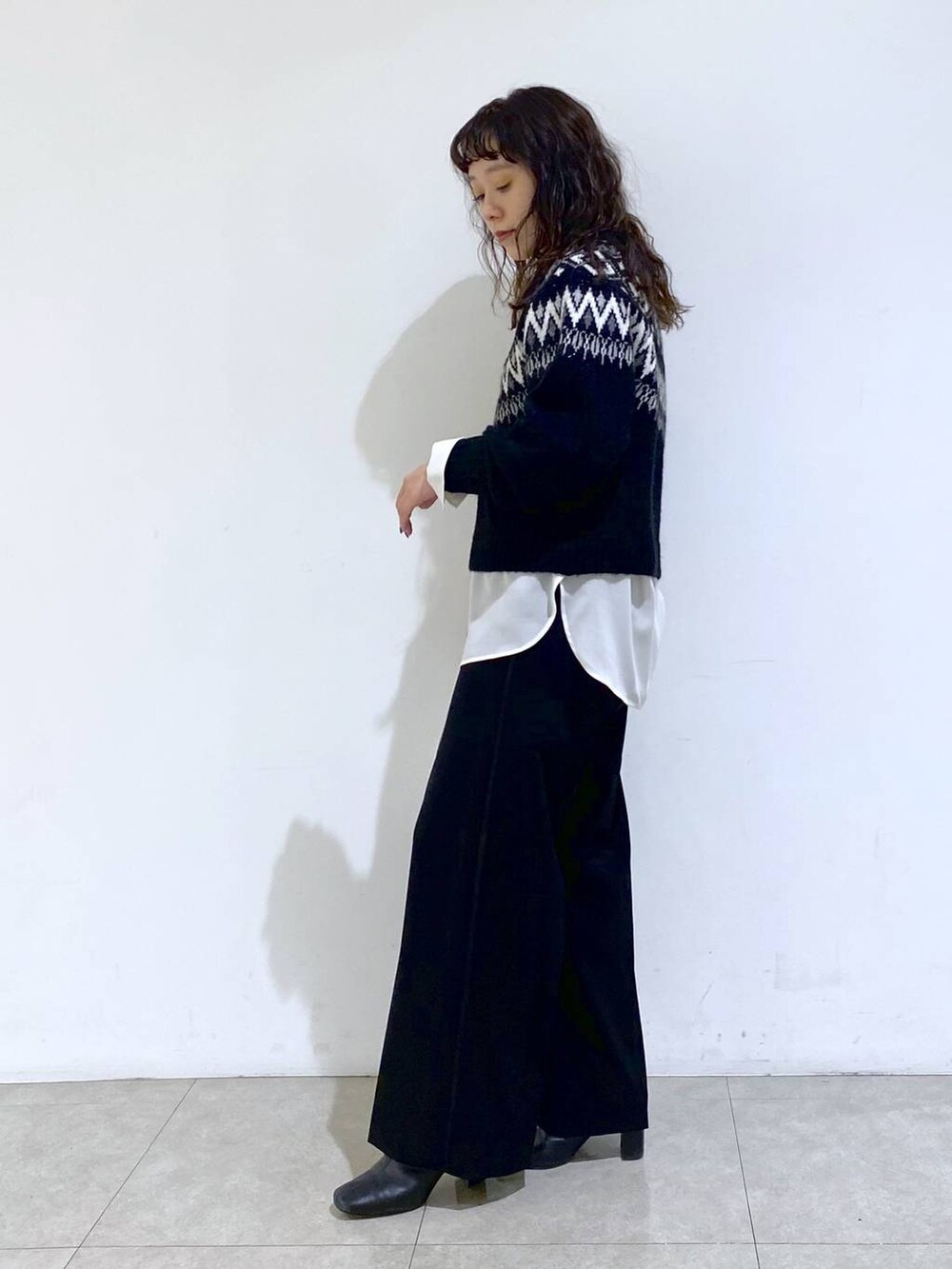 シルバー系のショルダーバッグ、ブラック系のTシャツ/カットソー、ホワイト系のシャツ/ブラウスを着用したレディースの冬コーディネートの3枚目の写真