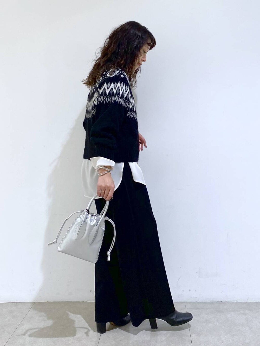 シルバー系のショルダーバッグ、ブラック系のTシャツ/カットソー、ホワイト系のシャツ/ブラウスを着用したレディースの冬コーディネートの6枚目の写真