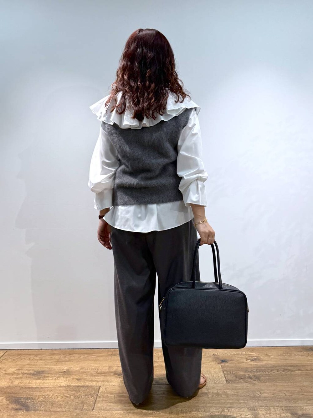 ホワイト系のシャツ/ブラウス、グレー系のベスト、ブラック系のハンドバッグを着用したレディースの夏コーディネートの3枚目の写真