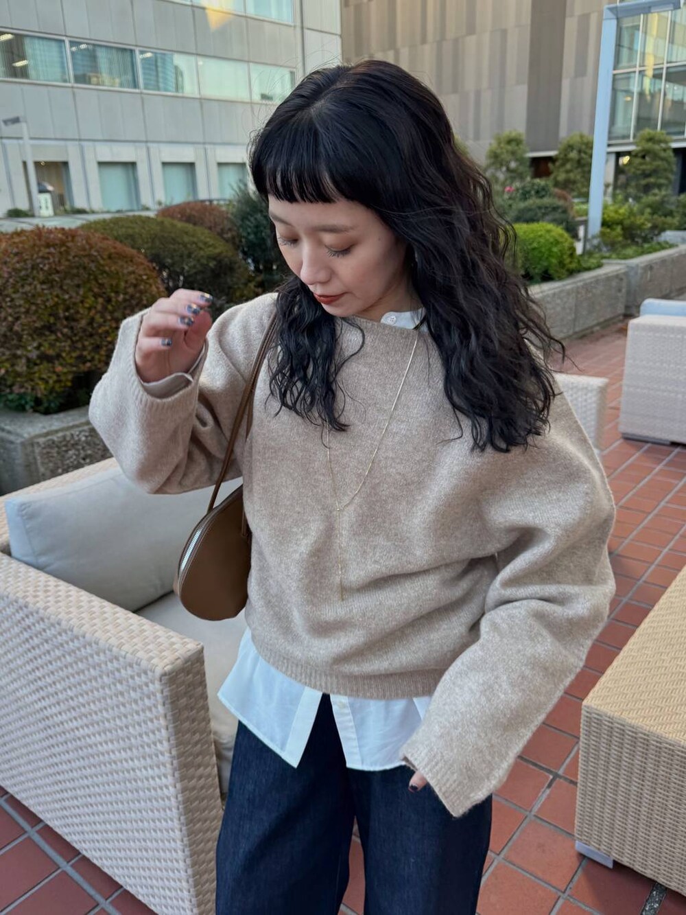 ブルー系のデニムパンツ、イエロー系のトートバッグ、ベージュ系のブーツを着用したレディースの冬コーディネートの3枚目の写真