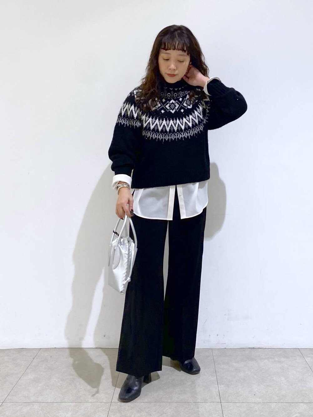 シルバー系のショルダーバッグ、ブラック系のTシャツ/カットソー、ホワイト系のシャツ/ブラウスを着用したレディースの冬コーディネートの7枚目の写真