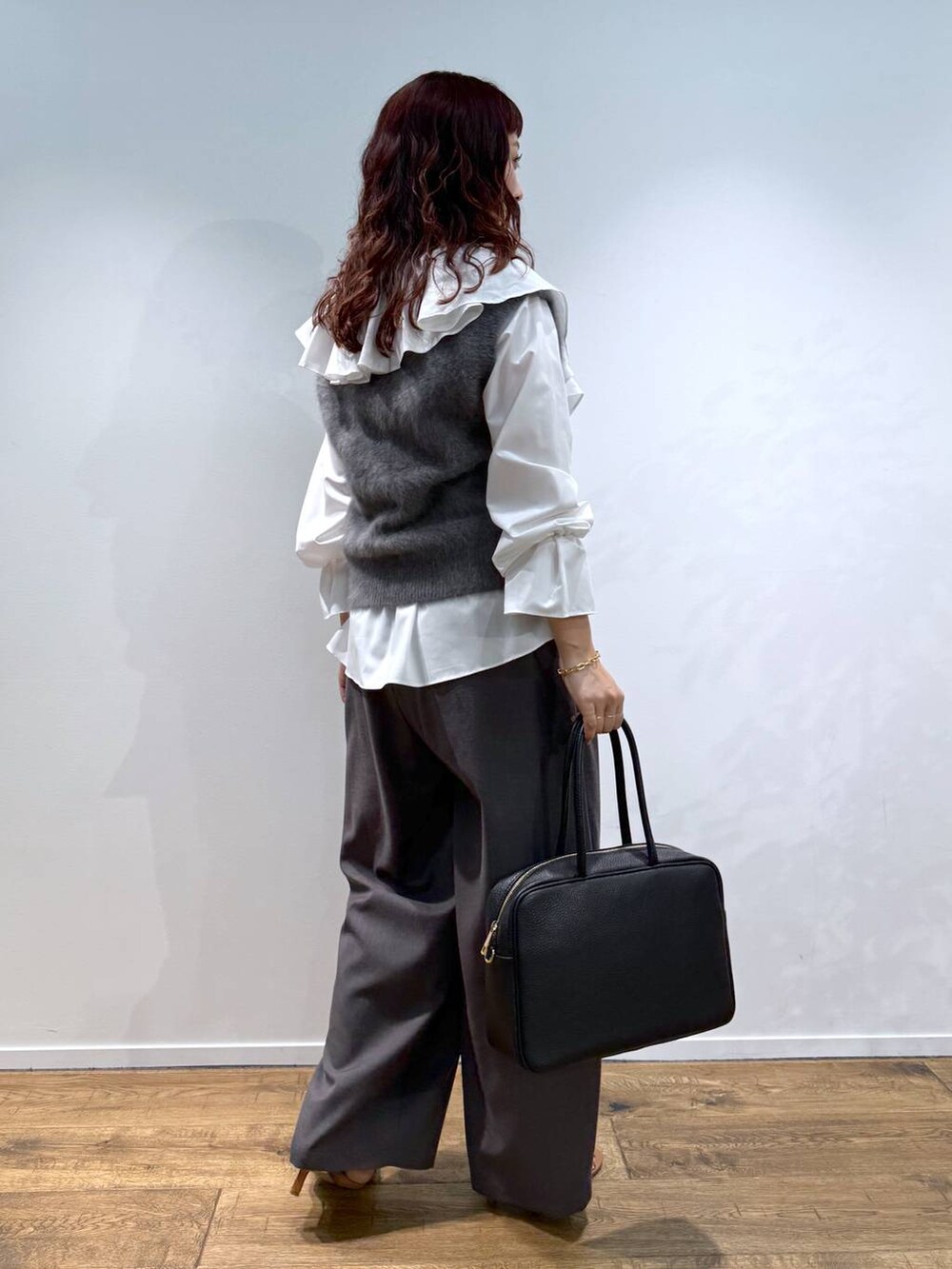 ホワイト系のシャツ/ブラウス、グレー系のベスト、ブラック系のハンドバッグを着用したレディースの夏コーディネートの4枚目の写真