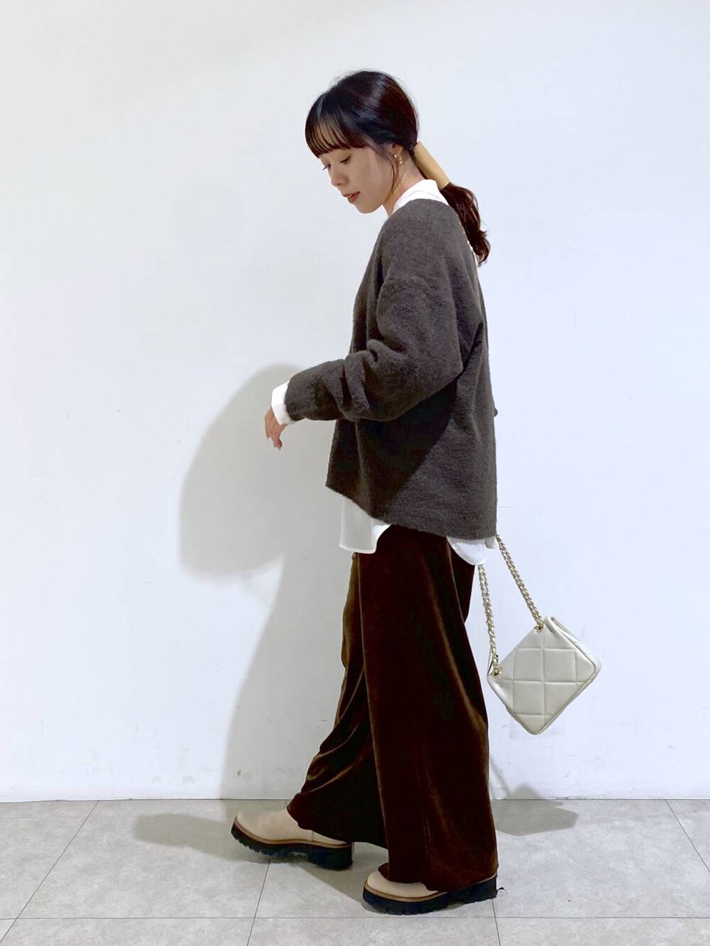 ベージュ系のブーツ、ホワイト系のショルダーバッグ、ホワイト系のシャツ/ブラウスを着用したレディースの冬コーディネートの3枚目の写真