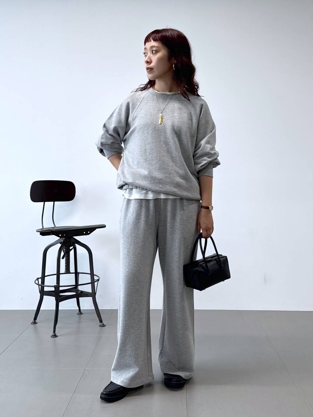 ブラック系のローファー、ホワイト系のシャツ/ブラウス、ブラック系のハンドバッグを着用したレディースの秋コーディネートの2枚目の写真