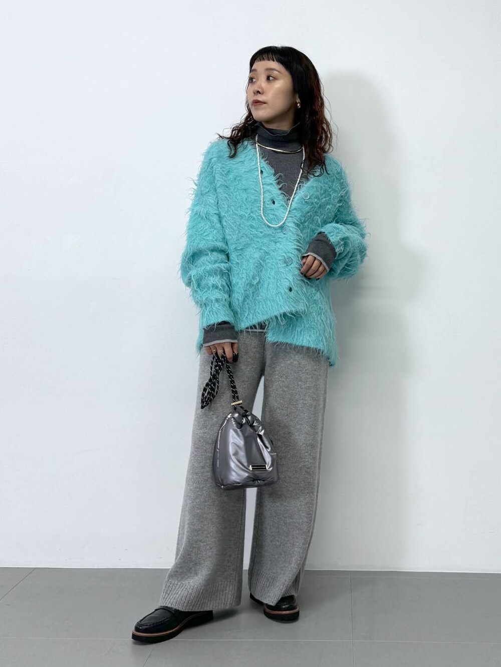 グレー系のその他パンツ、グレー系のニット/セーター、ブルー系のカーディガン/ボレロを着用したレディースの秋コーディネートの4枚目の写真