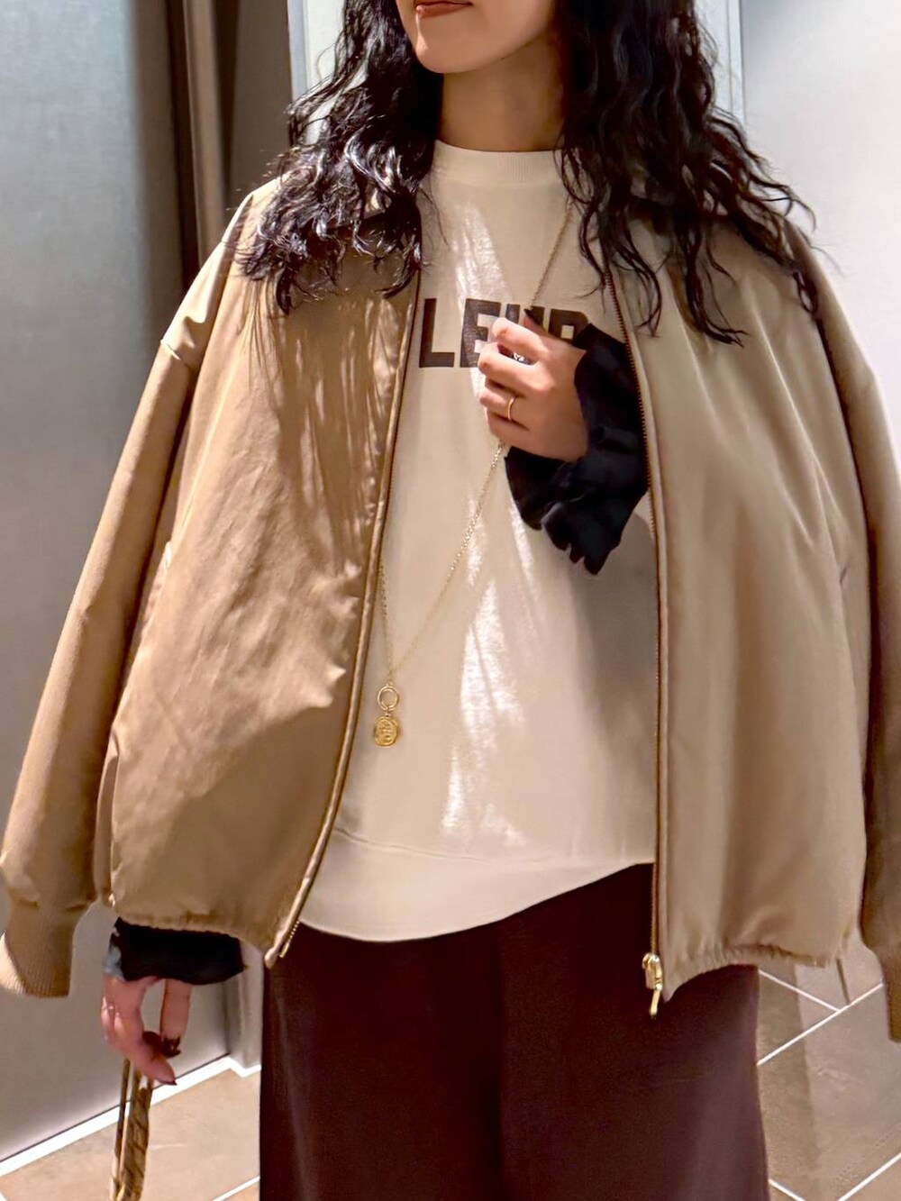 ベージュ系のブルゾン、ベージュ系のショルダーバッグ、ホワイト系のスウェットを着用したレディースの冬コーディネートの6枚目の写真