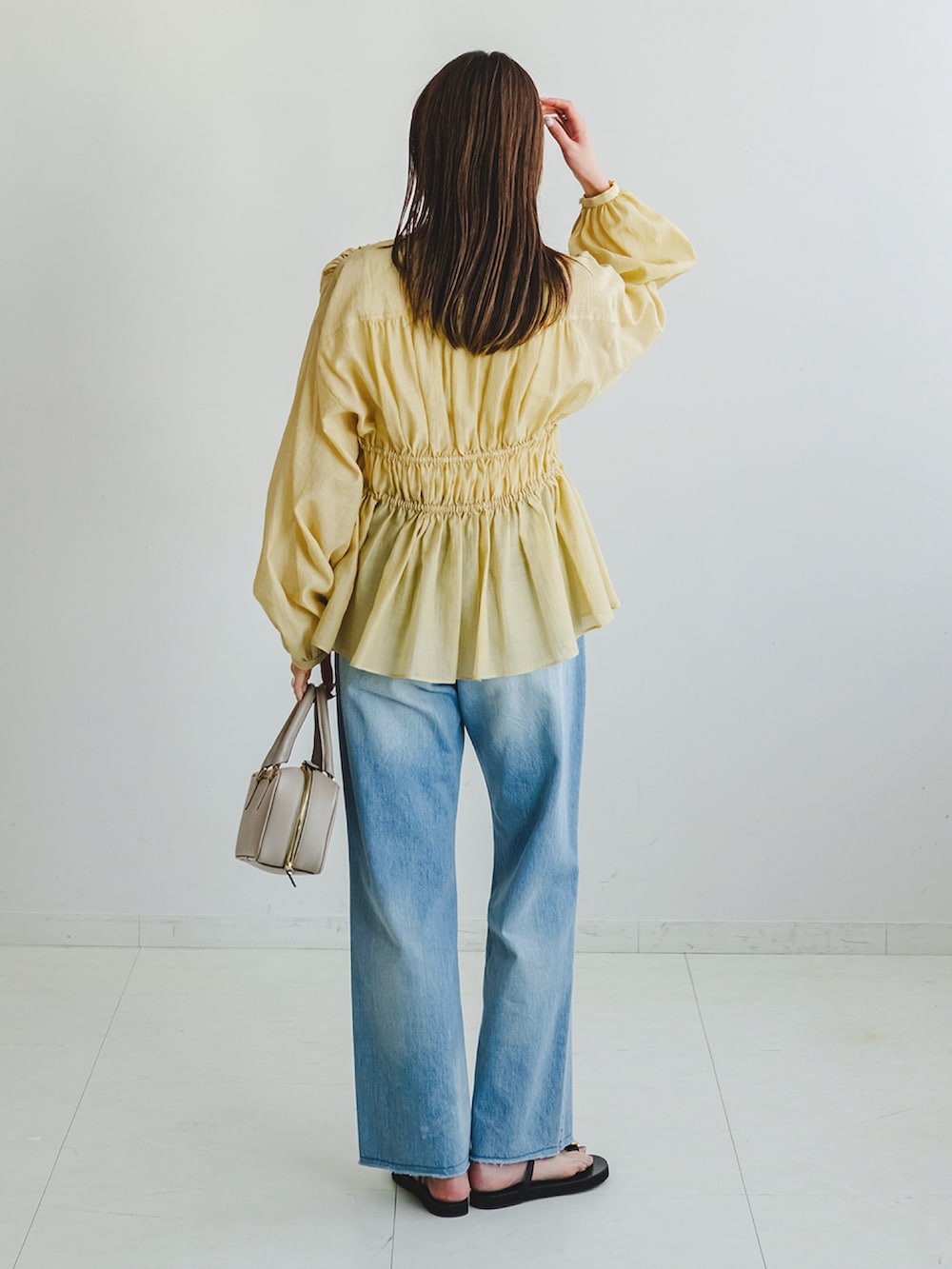 イエロー系のシャツ/ブラウス、ブルー系のデニムパンツ、ホワイト系のキャミソールを着用したレディースの春コーディネートの3枚目の写真