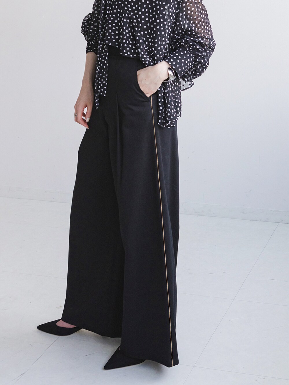 ブラック系のシャツ/ブラウス、ブラック系のスラックス、ブラック系のショルダーバッグを着用したレディースの秋コーディネートの4枚目の写真