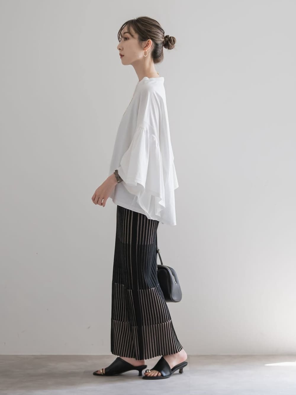 ホワイト系のTシャツ/カットソー、ブラック系のスカート、ブラウン系のボストンバッグを着用したレディースの夏コーディネートの3枚目の写真