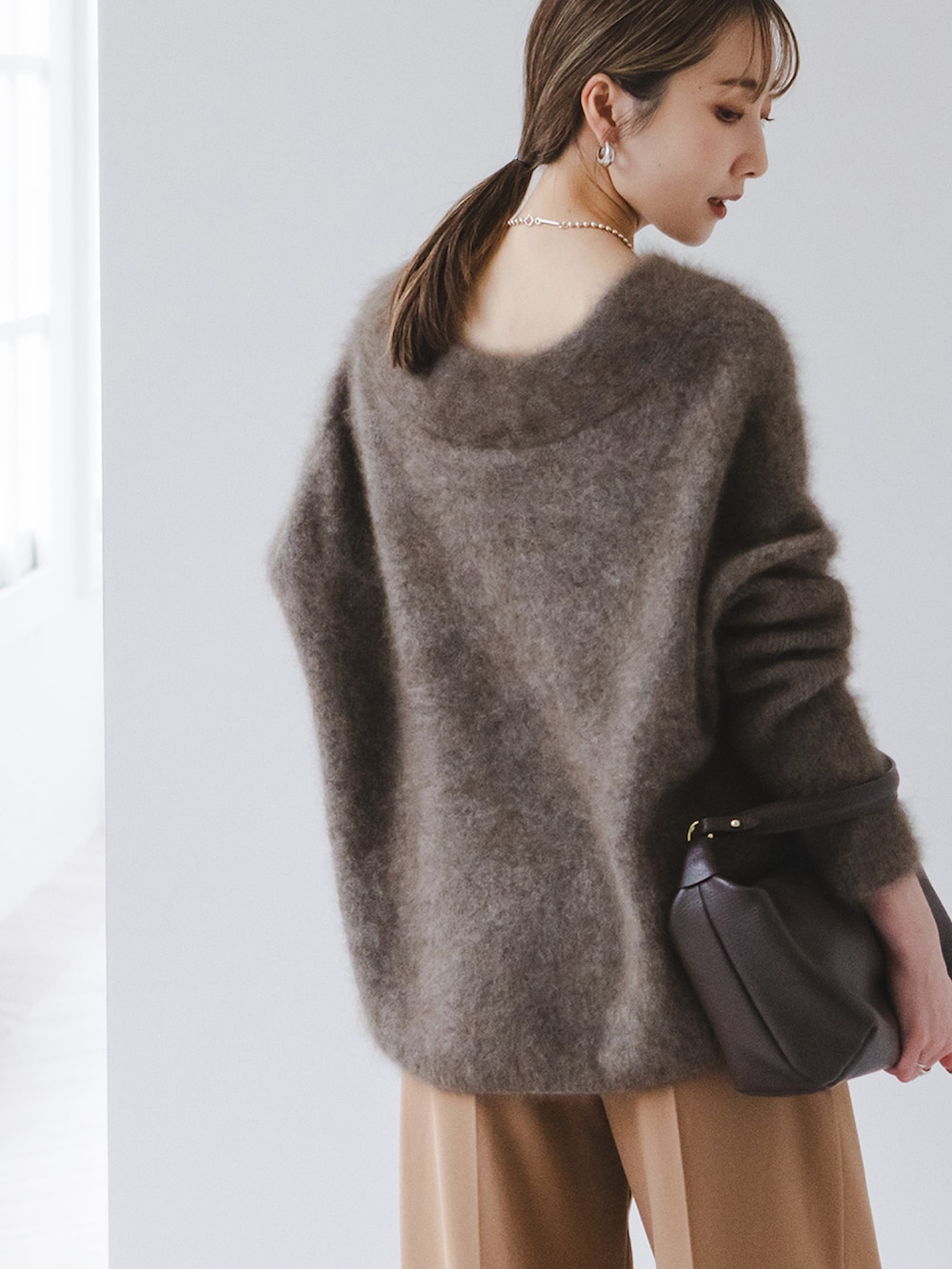 ブラウン系のニット/セーター、イエロー系のスラックス、ブラウン系のショルダーバッグを着用したレディースの秋コーディネートの4枚目の写真