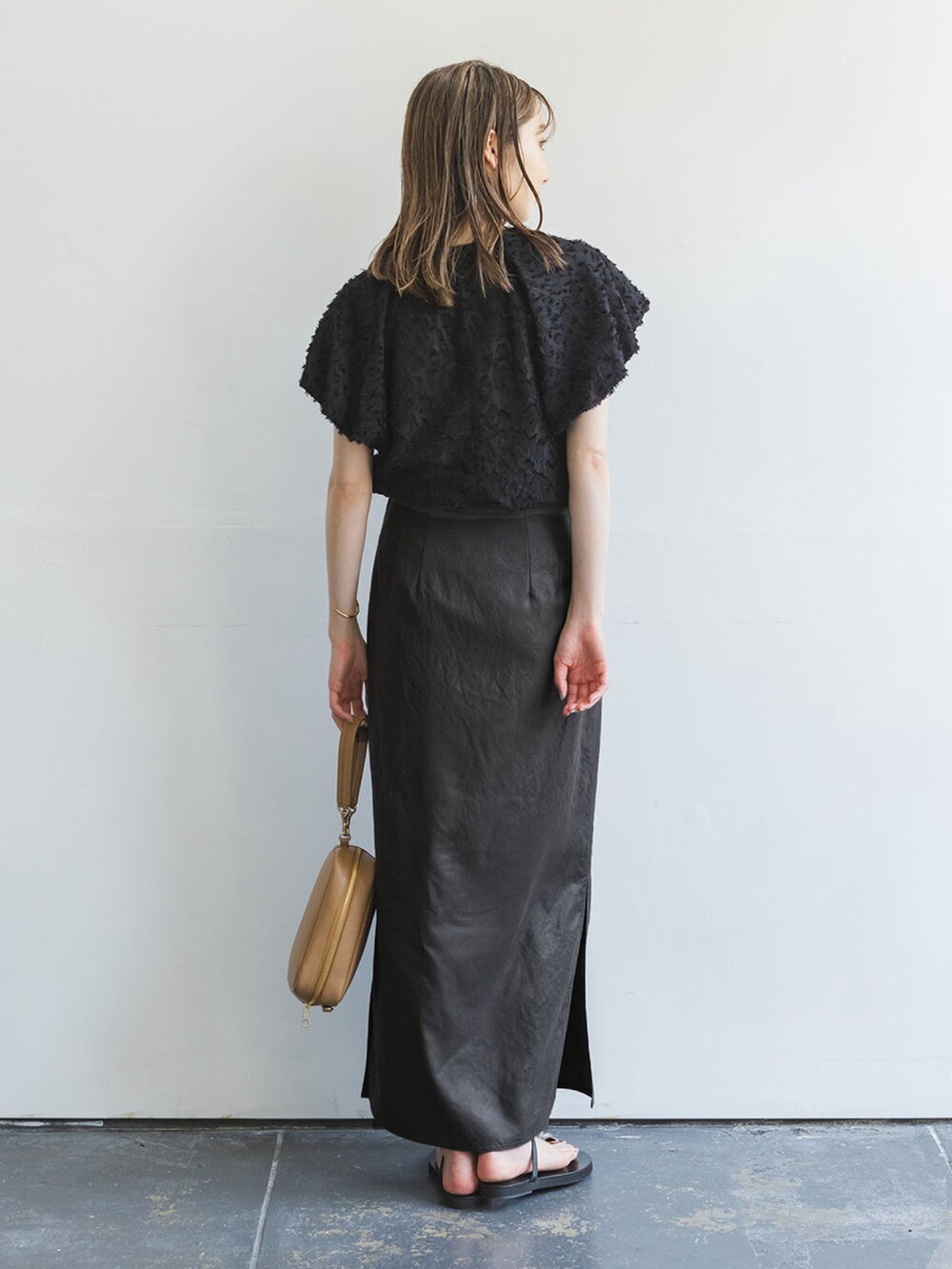 ブラウン系のスカート、ブラック系のシャツ/ブラウス、ベージュ系のショルダーバッグを着用したレディースの夏コーディネートの3枚目の写真