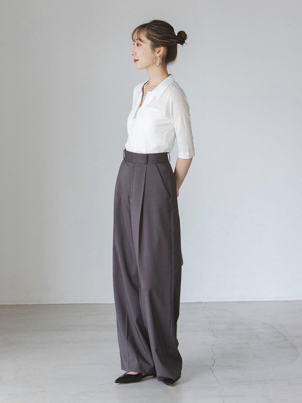 ホワイト系のTシャツ/カットソー、グレー系のスラックス、イエロー系のショルダーバッグを着用したレディースの夏コーディネートの2枚目の写真