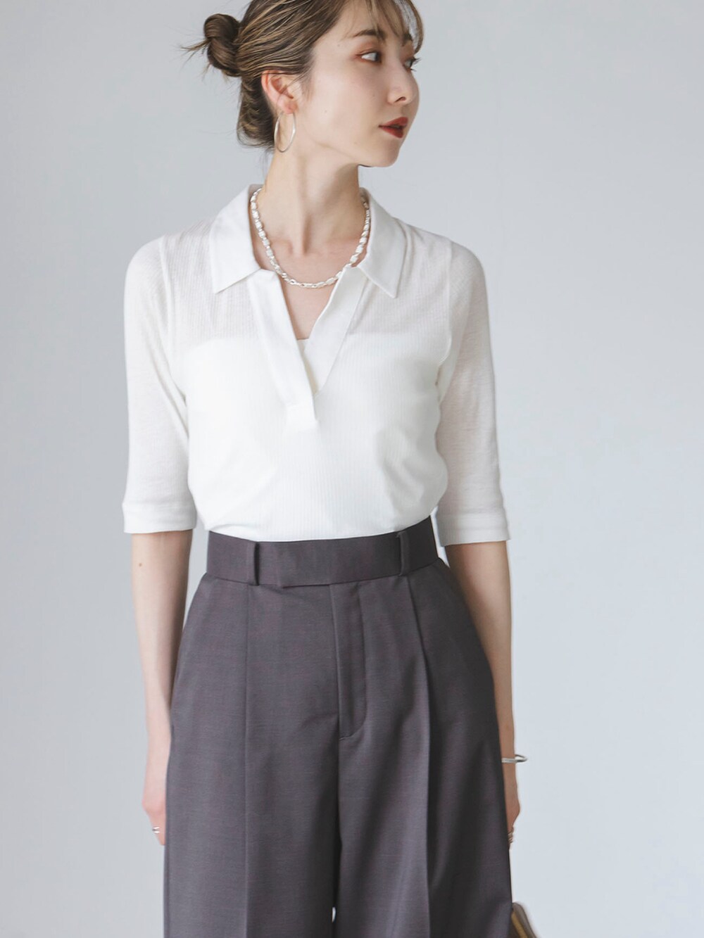 ホワイト系のTシャツ/カットソー、グレー系のスラックス、イエロー系のショルダーバッグを着用したレディースの夏コーディネートの3枚目の写真