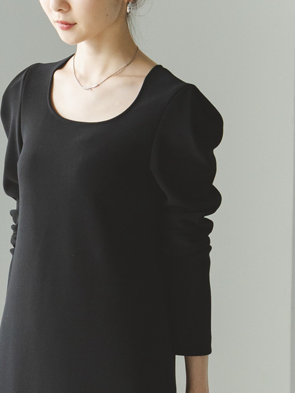 ブラック系のワンピース、ブラック系のバッグ、ブラック系のローファーを着用したレディースの秋コーディネートの3枚目の写真