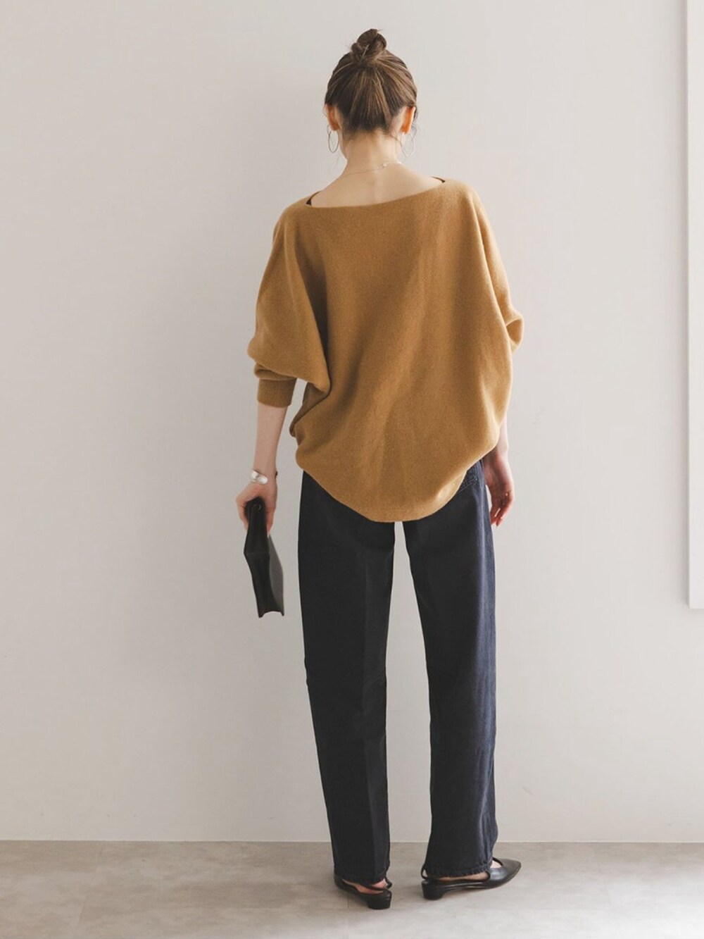 イエロー系のニット/セーター、ブラック系のデニムパンツ、ブラック系のパンプスを着用したレディースの秋コーディネートの2枚目の写真