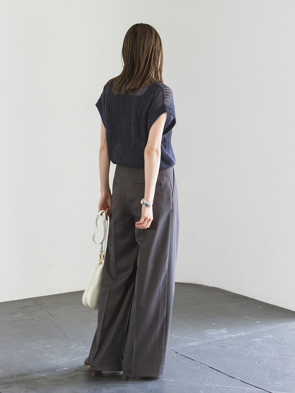 ブルー系のベスト、グレー系のスラックス、ブラック系のタンクトップを着用したレディースの夏コーディネートの2枚目の写真