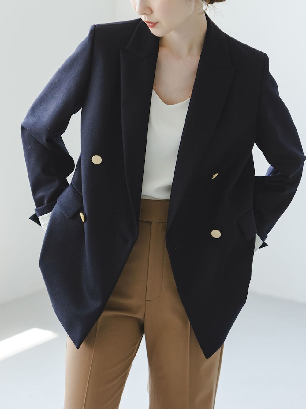 ブラック系のショルダーバッグ、イエロー系のスラックス、ホワイト系のキャミソールを着用したレディースの秋コーディネートの4枚目の写真