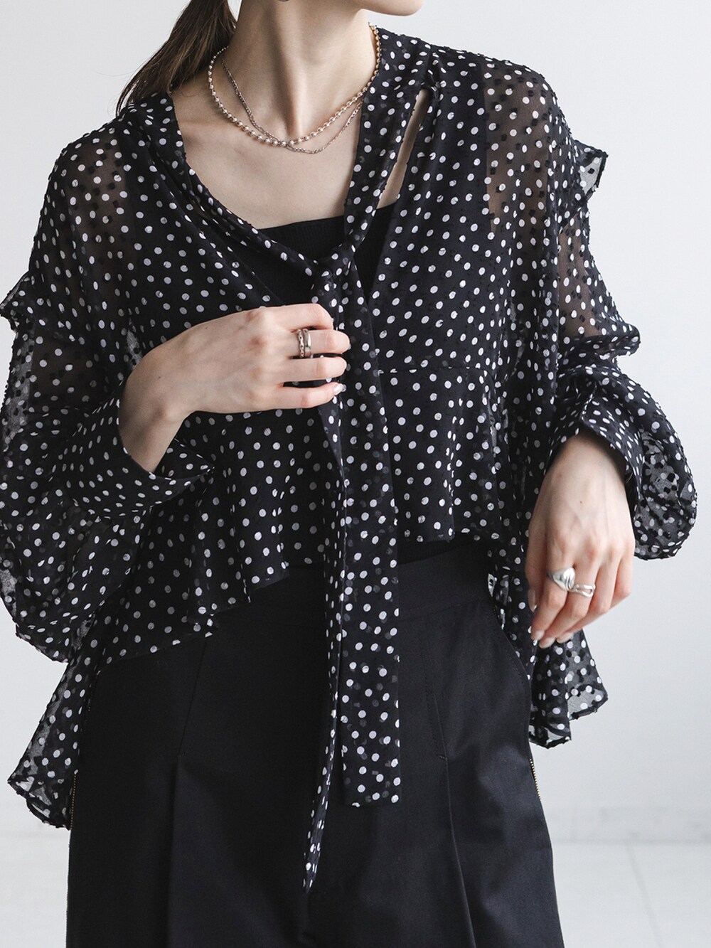 ブラック系のシャツ/ブラウス、ブラック系のスラックス、ブラック系のショルダーバッグを着用したレディースの秋コーディネートの3枚目の写真