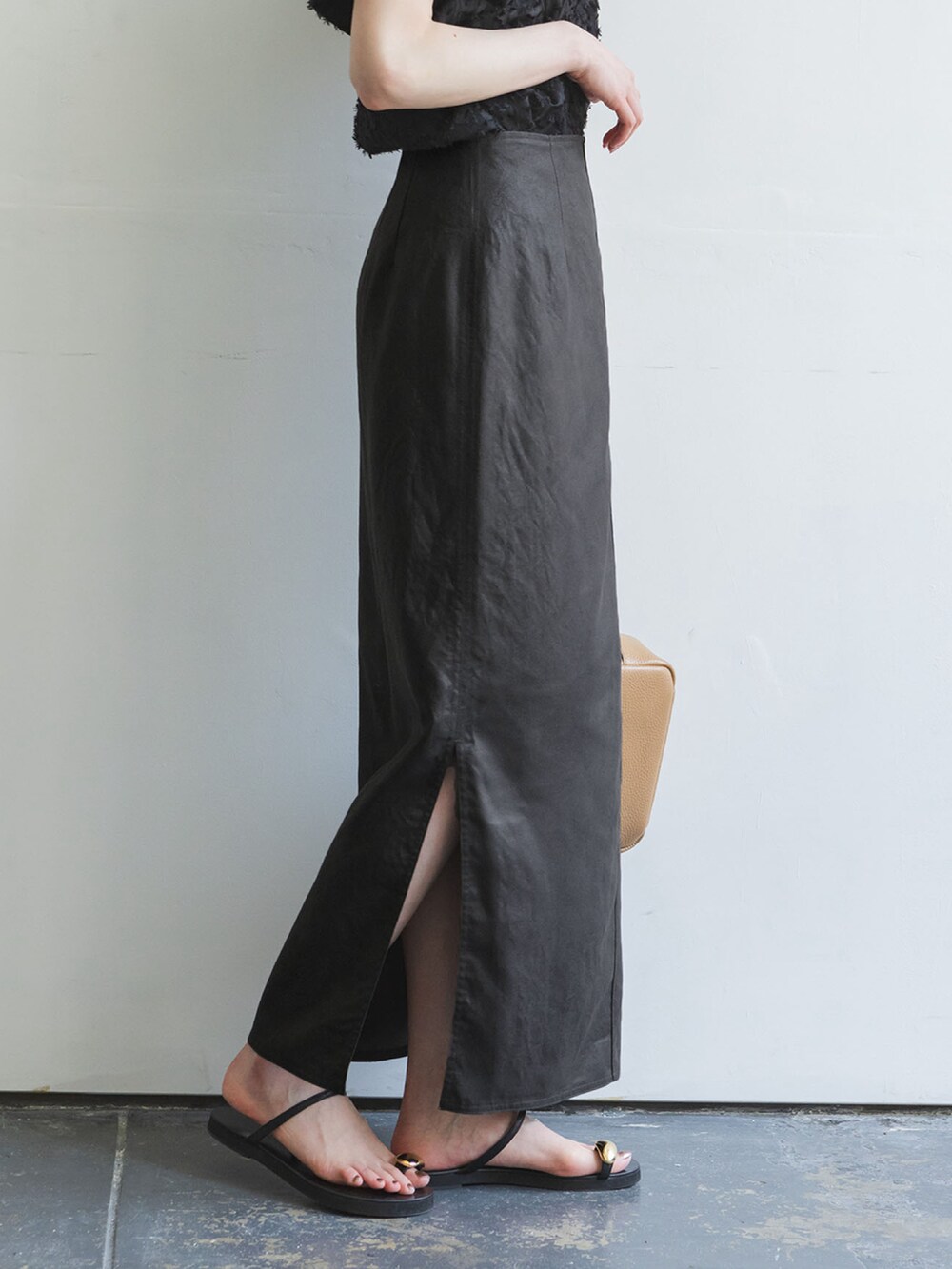 ブラウン系のスカート、ブラック系のシャツ/ブラウス、ベージュ系のショルダーバッグを着用したレディースの夏コーディネートの2枚目の写真