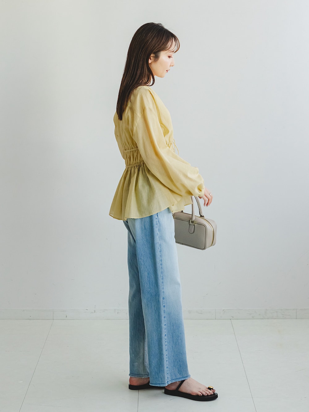 イエロー系のシャツ/ブラウス、ブルー系のデニムパンツ、ホワイト系のキャミソールを着用したレディースの春コーディネートの2枚目の写真