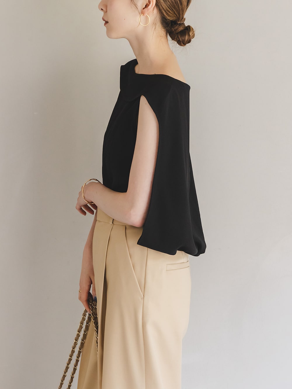 ブラック系のシャツ/ブラウス、ベージュ系のスラックス、ベージュ系のショルダーバッグを着用したレディースの夏コーディネートの4枚目の写真