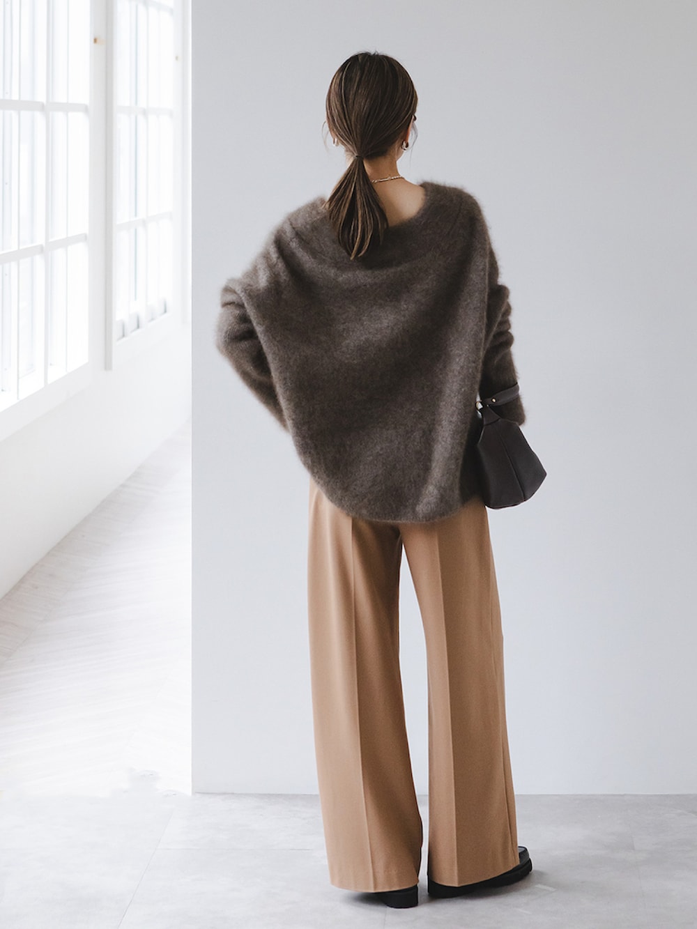 ブラウン系のニット/セーター、イエロー系のスラックス、ブラウン系のショルダーバッグを着用したレディースの秋コーディネートの3枚目の写真