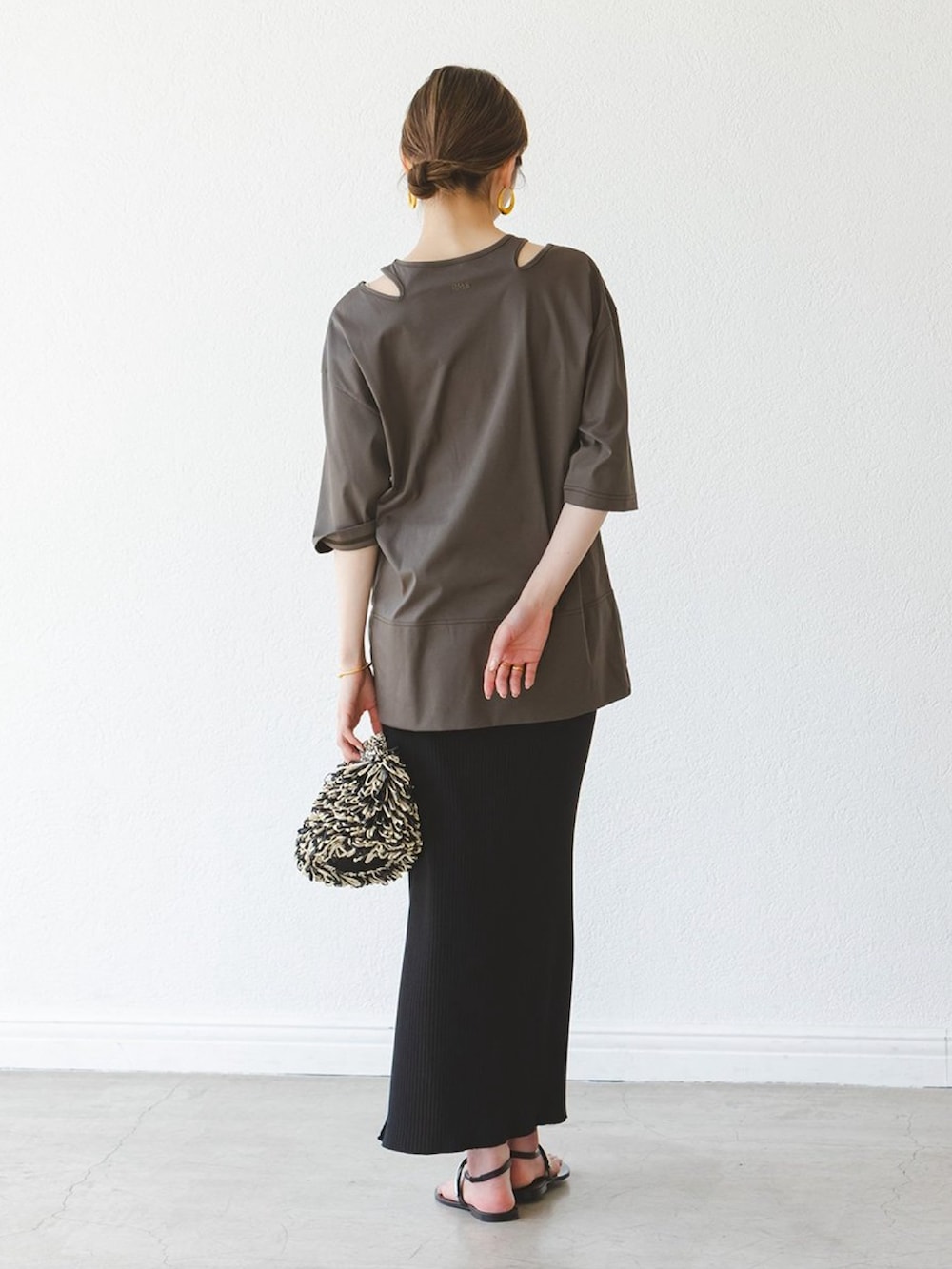 グリーン系のTシャツ/カットソー、ブラック系のスカート、ブラック系のサンダルを着用したレディースの夏コーディネートの2枚目の写真