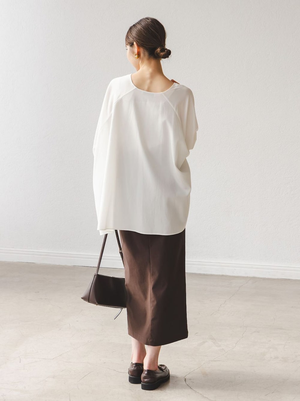 ホワイト系のシャツ/ブラウス、ブラウン系のスカート、ブラウン系のローファーを着用したレディースの秋コーディネートの3枚目の写真