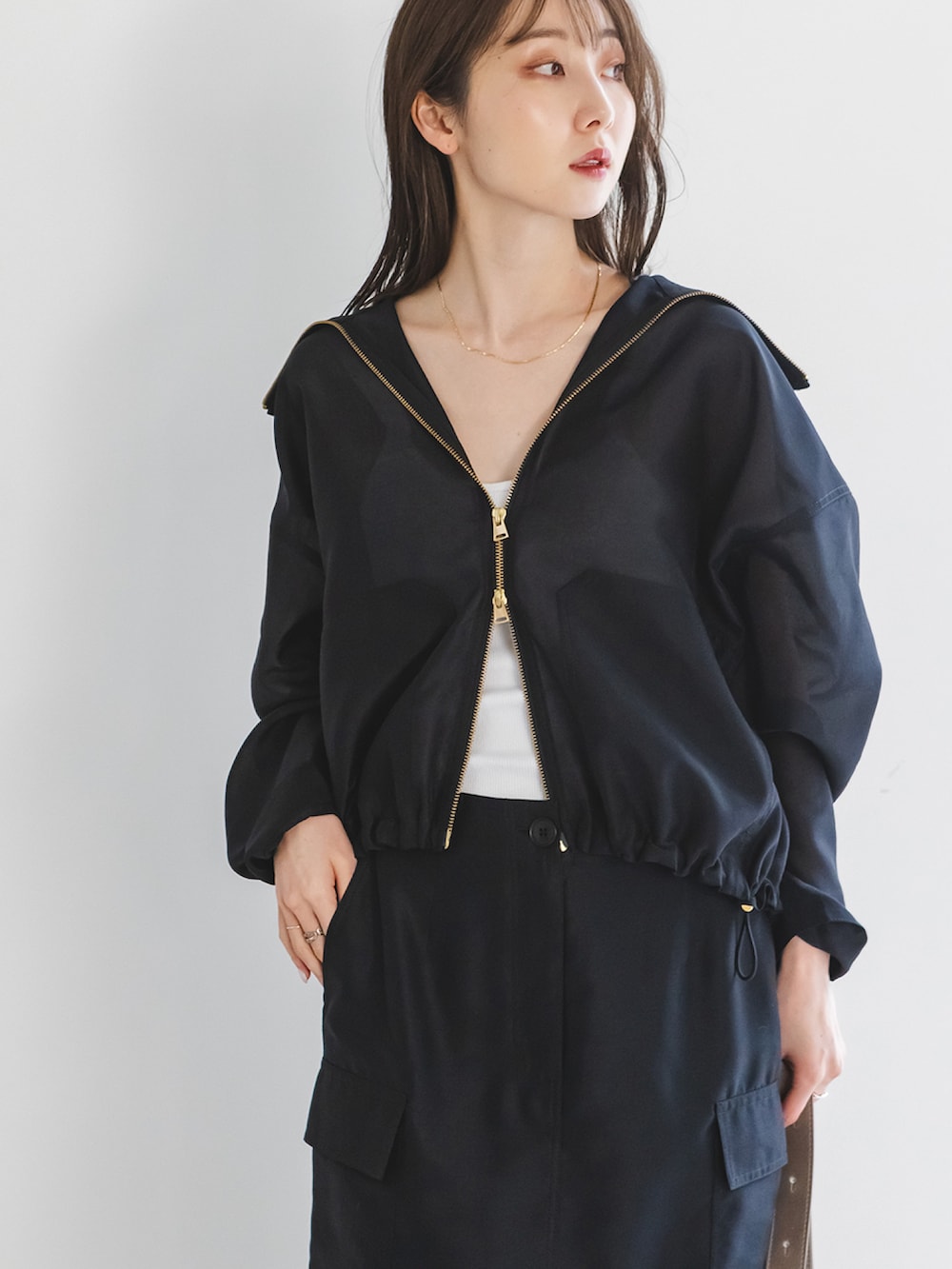 ブラック系のその他アウター、ブラック系のスカート、ブラウン系のショルダーバッグを着用したレディースの春コーディネートの3枚目の写真