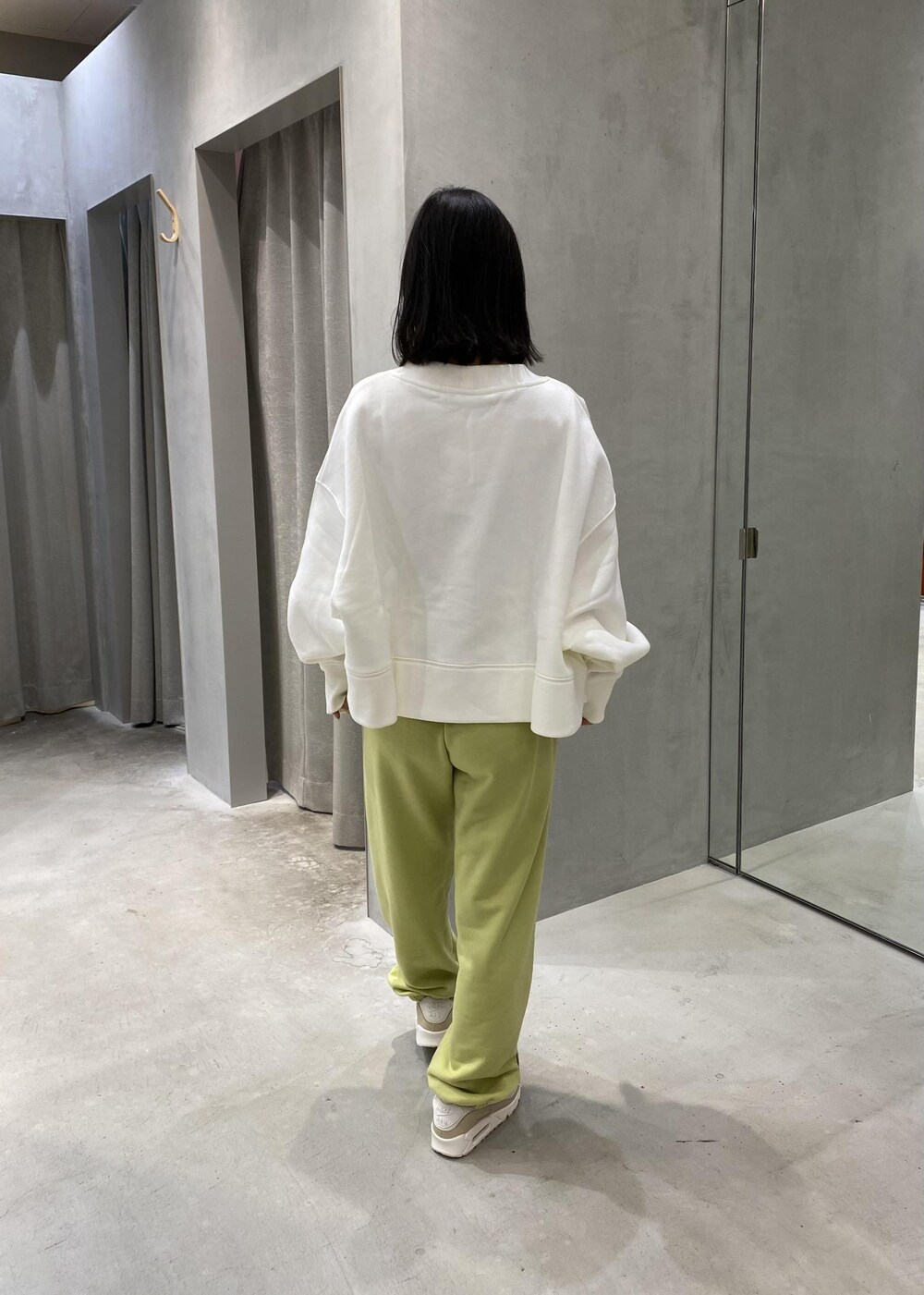 グリーン系のその他パンツ、ホワイト系のカーディガン/ボレロ、ホワイト系のスニーカーを着用したレディースの冬コーディネートの3枚目の写真