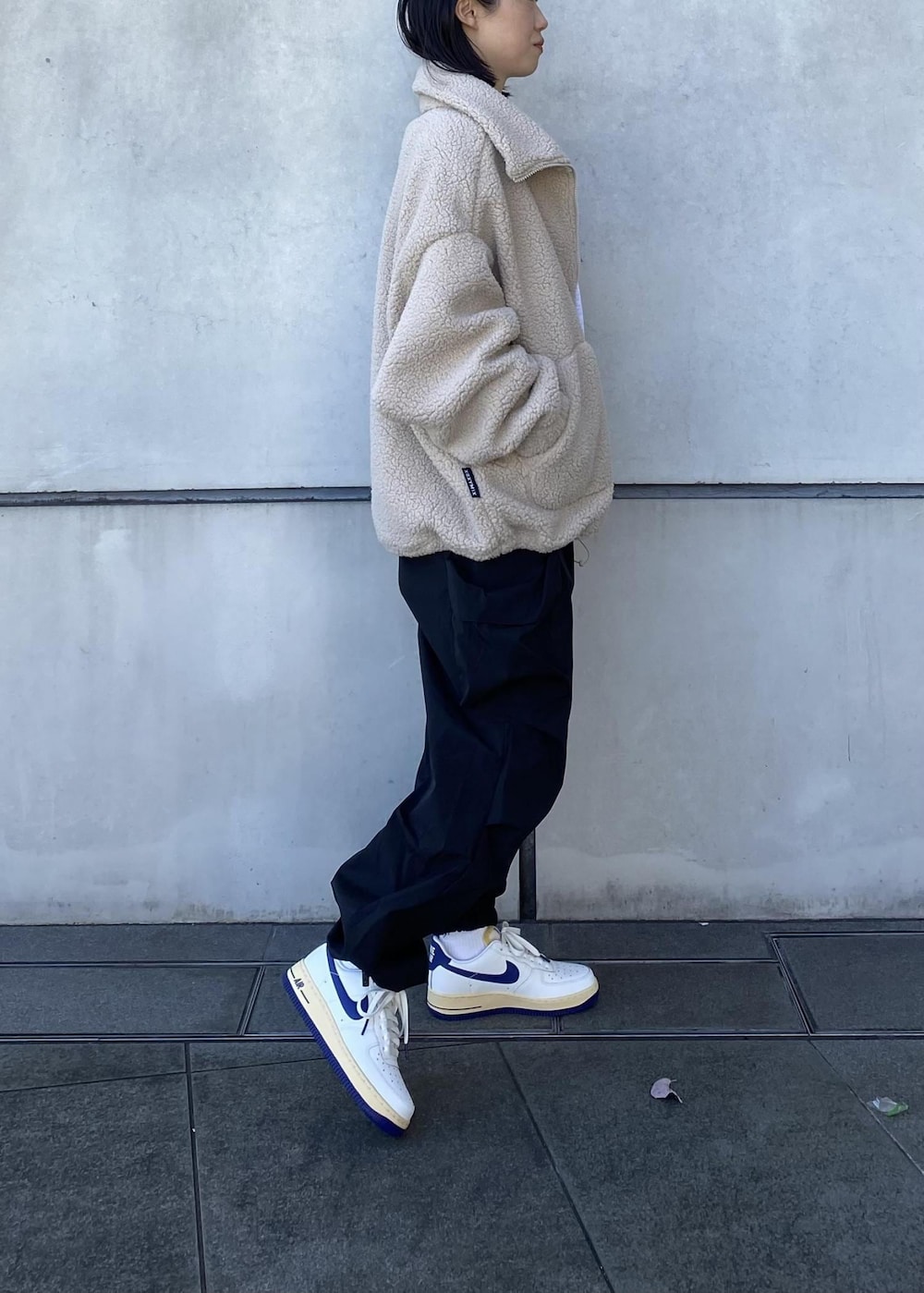 ホワイト系のスニーカー、ブラック系のその他パンツ、ベージュ系のその他アウターを着用したレディースの冬コーディネートの2枚目の写真