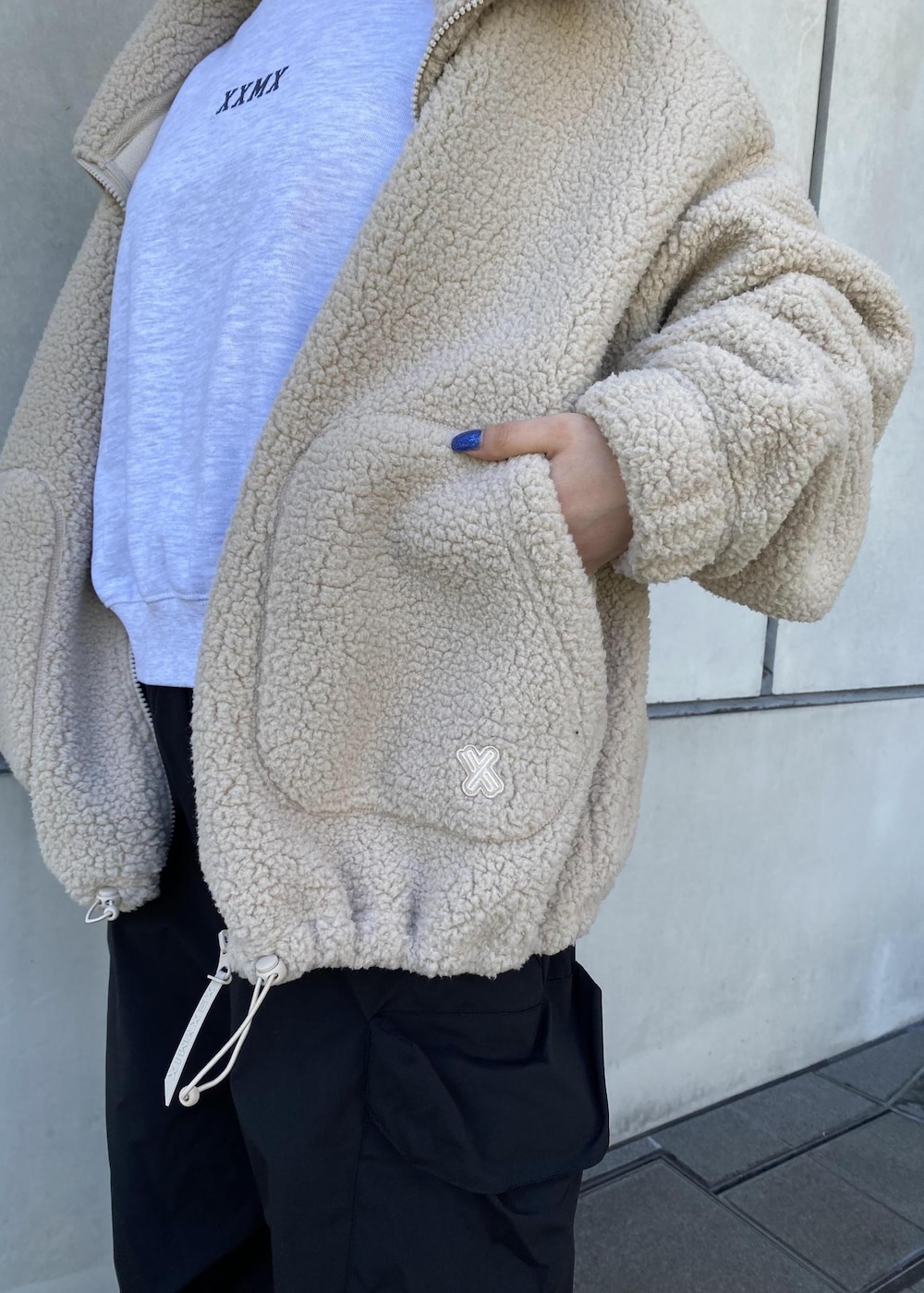 ホワイト系のスニーカー、ブラック系のその他パンツ、ベージュ系のその他アウターを着用したレディースの冬コーディネートの6枚目の写真