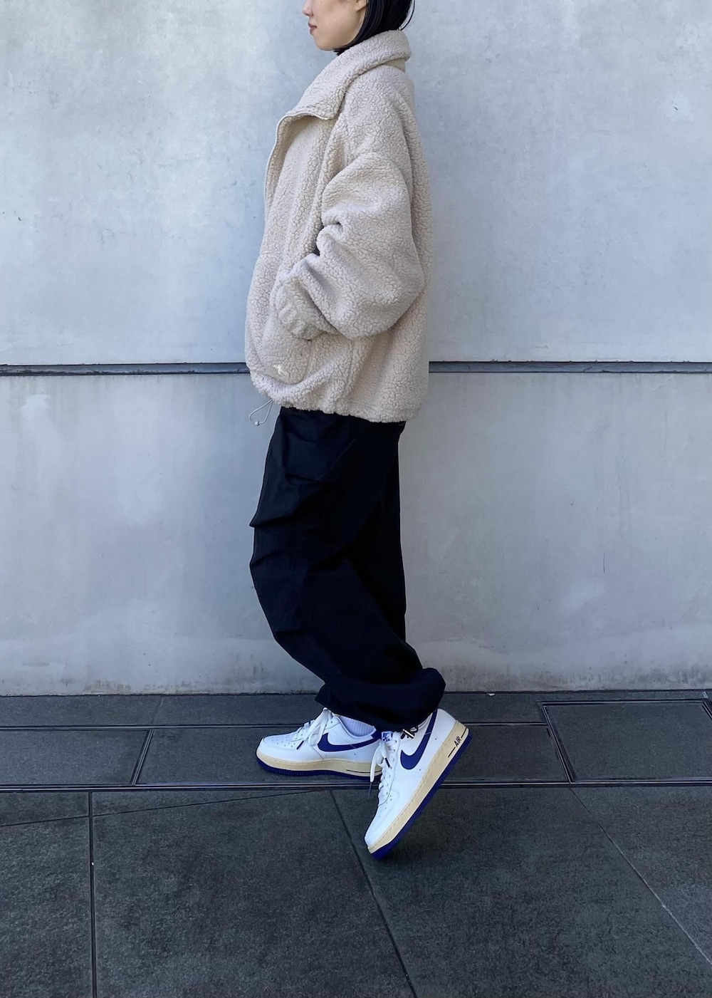 ホワイト系のスニーカー、ブラック系のその他パンツ、ベージュ系のその他アウターを着用したレディースの冬コーディネートの3枚目の写真