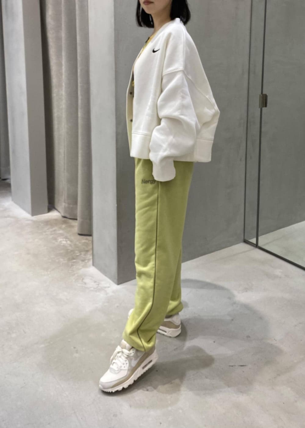 グリーン系のその他パンツ、ホワイト系のカーディガン/ボレロ、ホワイト系のスニーカーを着用したレディースの冬コーディネートの2枚目の写真