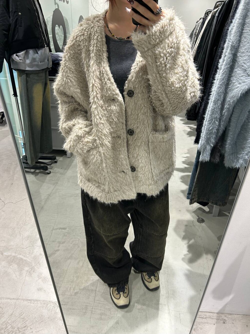 ブラック系のデニムパンツ、ベージュ系のカーディガン/ボレロを着用したレディースの秋コーディネートの2枚目の写真