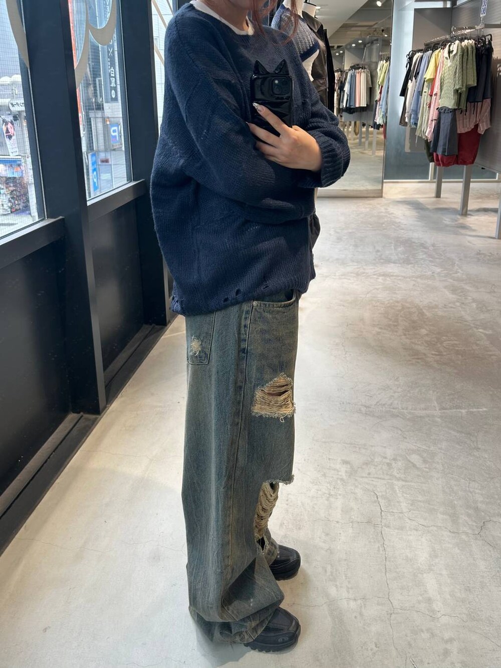 ブルー系のニット/セーター、ブルー系のデニムパンツを着用したレディースの秋コーディネートの3枚目の写真