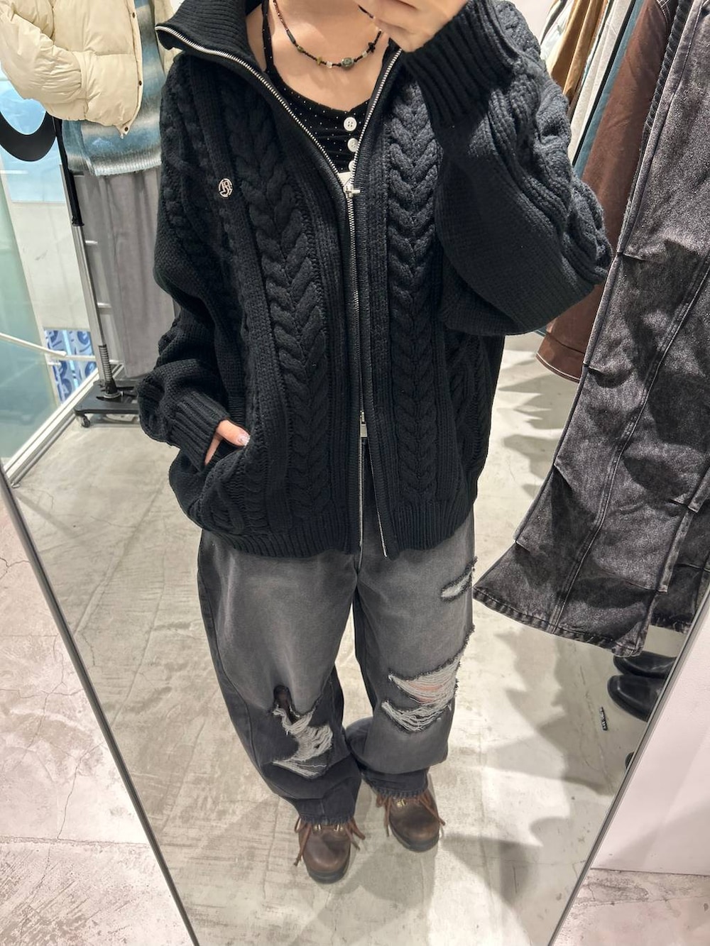 ブラック系のデニムパンツ、ブラック系のニット/セーターを着用したレディースの冬コーディネートの2枚目の写真