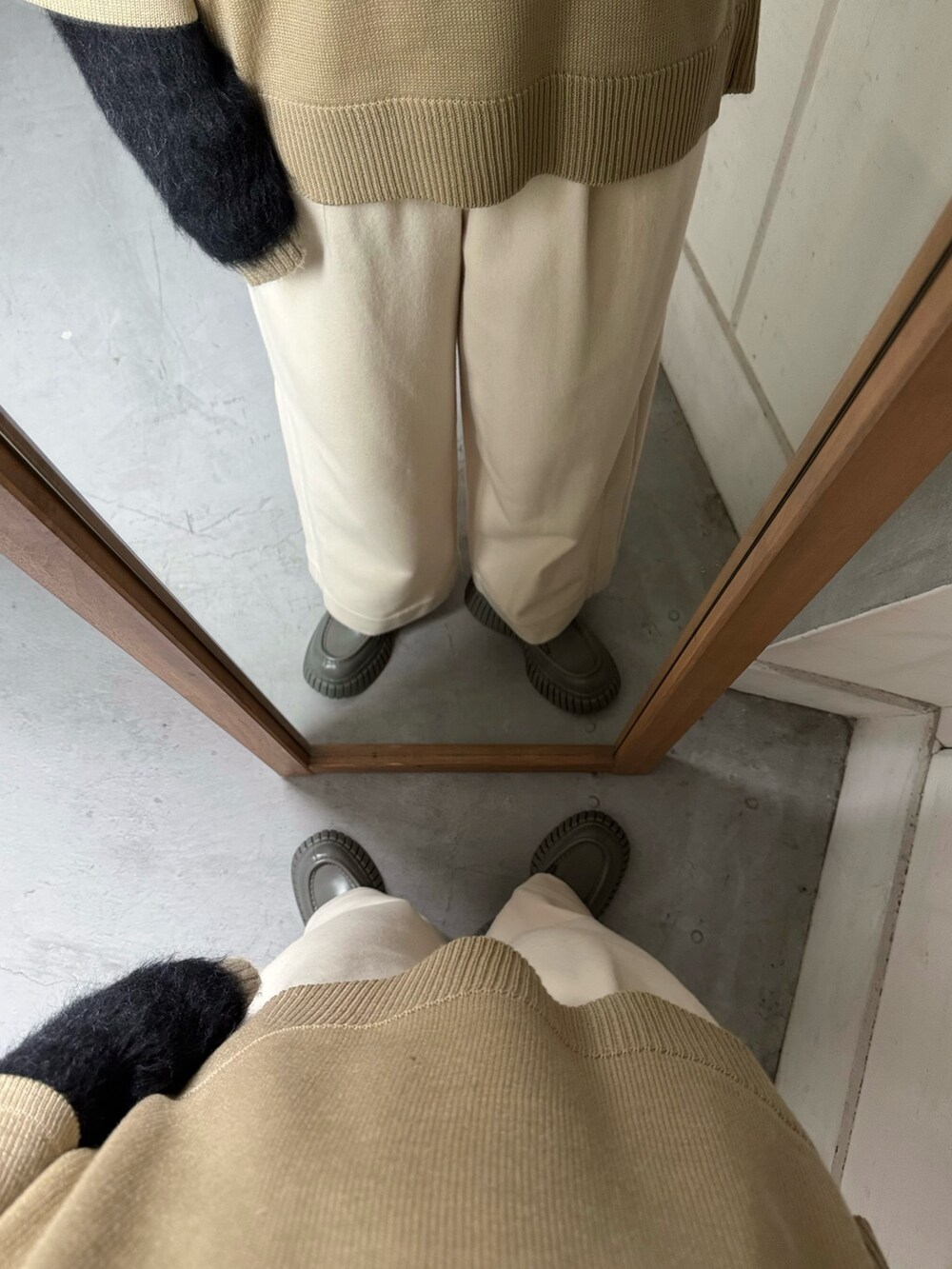 ベージュ系のニット/セーター、ブラック系のダウンベスト、ホワイト系のその他パンツを着用したレディースの冬コーディネートの3枚目の写真