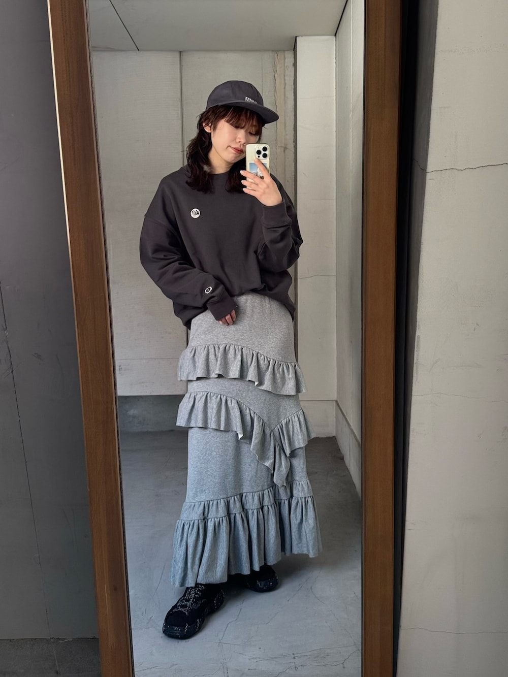 グレー系のスウェット、グレー系のスカート、ホワイト系のトートバッグを着用したレディースの冬コーディネートの5枚目の写真