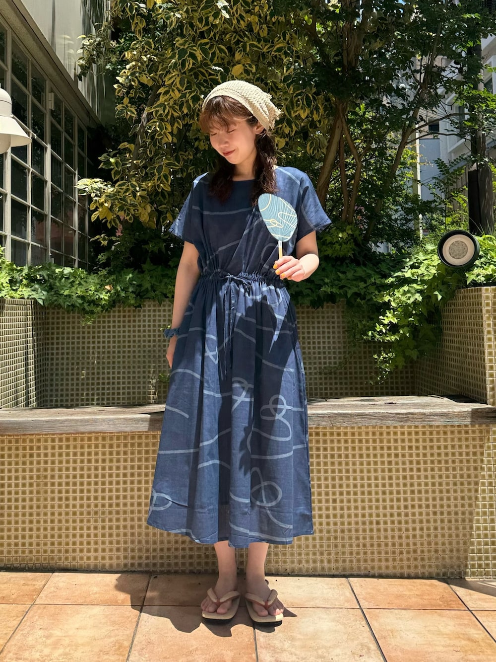 ブルー系のワンピース、ベージュ系のサンダル、ブルー系のその他雑貨を着用したレディースの夏コーディネートの2枚目の写真